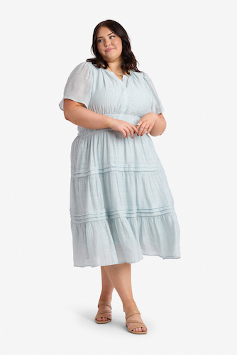 Woman wearing a light blue tiered modest midi dress