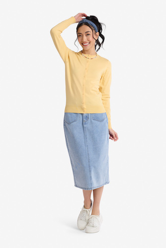 Woman wearing a long denim skirt and yellow cardigan sweater