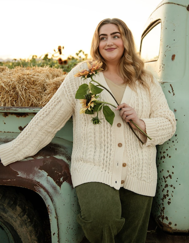 Woman holding flowers and standing in front of a mint colored truck