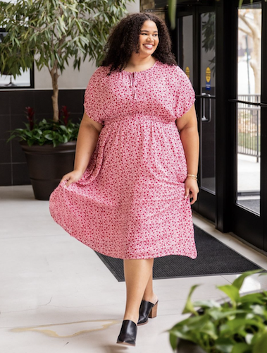 Woman walking indoors with a pink and red dress